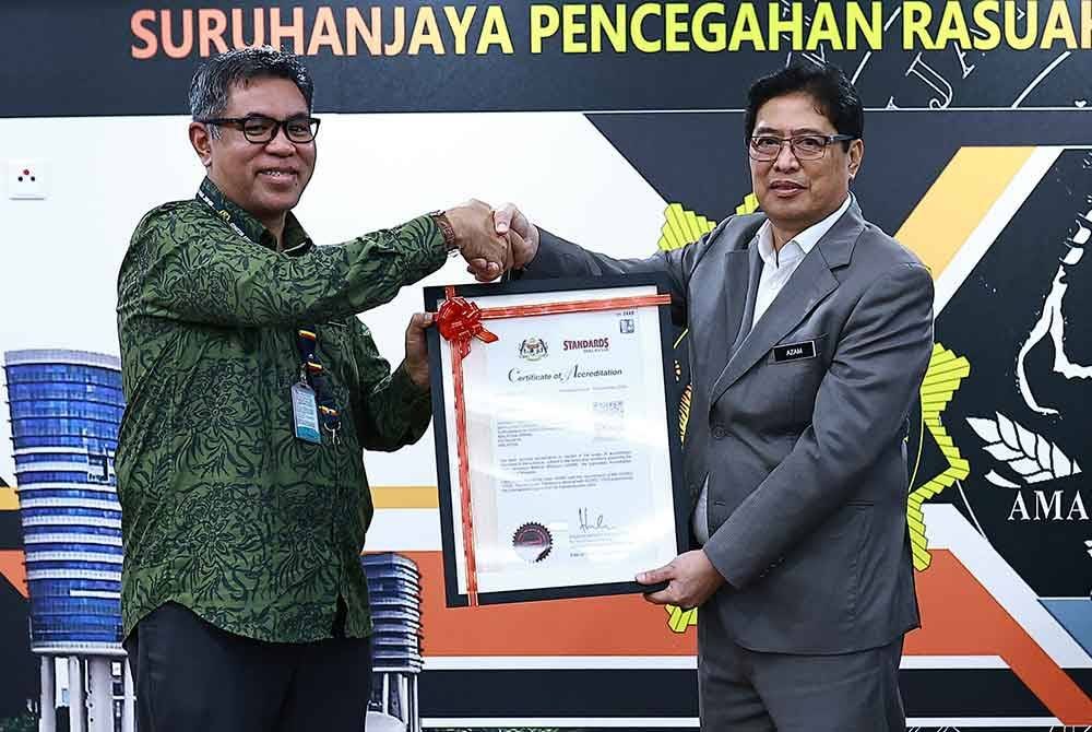 Hussalmizzar (kiri) menyampaikan Sijil Akreditasi kepada Azam sempena majlis penyerahan Sijil Akreditasi MS ISO/IEC 17025:2017 dan perasmian makmal forensik BFT SPRM, di Putrajaya pada Khamis. Foto SPRM