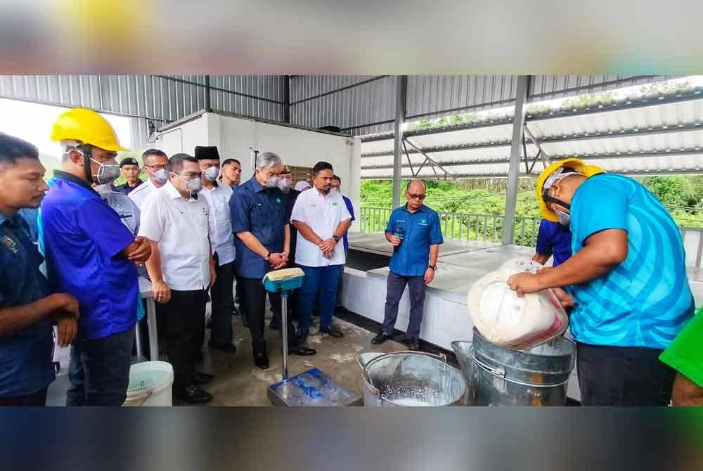 Ahmad Zahid (tiga dari kiri) melihat proses pembuatan lateks di Kompleks Lateks Agropolitan Chemomoi pada Khamis.