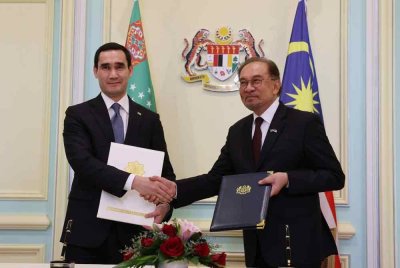 Anwar (kanan) bersama Presiden Turkmenistan Serdar Berdimuhamedow bertukar Dokumen Perjanjian Pesefahaman (MOU) di Bangunan Perdana Putra pada Khamis. Foto Bernama