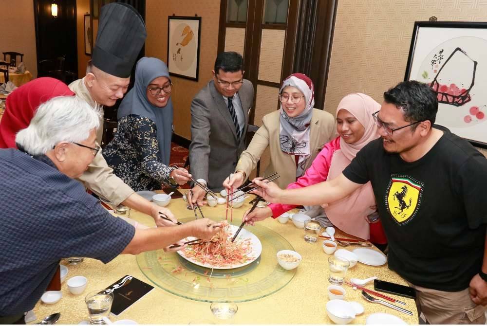 PATRICK NG (enam dari kanan) bersama Timbalan Pengarah Urusan Mardhiyyah Hotel & Suites, Munirah Mohamed Rafik (lima dari kanan) ketika melakukan gimik melambung isi Yee Sang. 