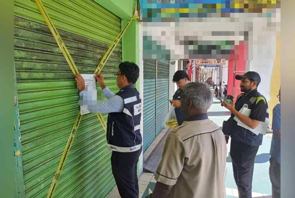 Penguatkuasa MBPP melekatkan notis penutupan 14 hari di pintu premis berkenaan. Foto MBPP