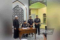 Mohd Yusoff (dua dari kiri) menandatangani buku kedatangan di Masjid Raudhatul Muttaqin, Kemumin, di Kota Bharu. FOTO SINAR HARIAN-ADILA SHARINNI WAHID.