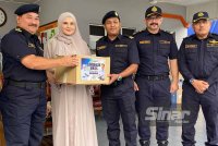 Muhammad Kifli (kiri) menyampaikan sumbangan kepada anggota yang terkesan dengan banjir pada Program Sumbangan Bantuan Banjir oleh Skuad Ihsan Madani JPJ Malaysia di Kelantan.