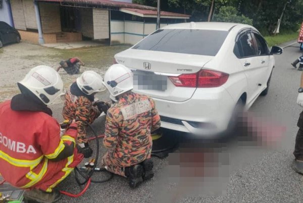 Mangsa maut di lokasi kejadian selepas tersepit di bawah kereta. Foto JBPM