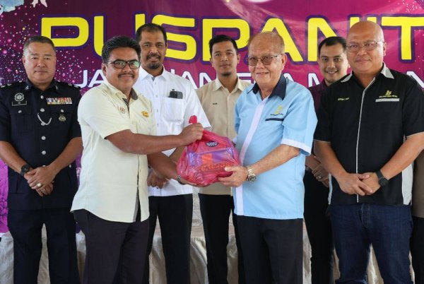 Nik Raisnan (tiga dari kiri) menyaksikan penyerahan bantuan makanan daripada Datuk Tan Kim Keah (tiga dari kanan) kepada wakil jabatan untuk diagihkan kepada penduduk terkesan banjir pada Majlis Penyerahan Bantuan Banjir di Pejabat Tanah dan Jajahan Gua Musang, pada Ahad. Foto Bernama