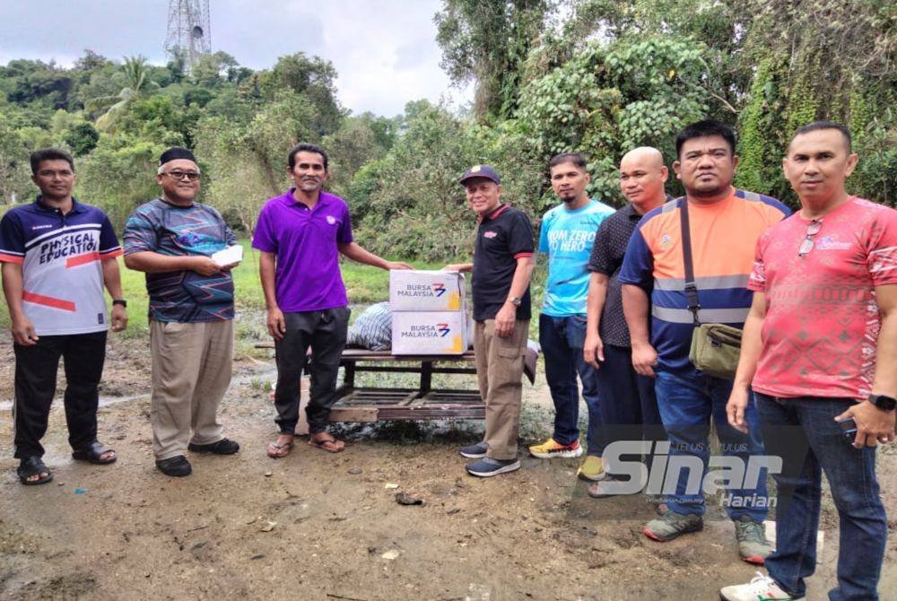 Muhammad Nasir (empat dari kanan) bersama mangsa banjir di Kampung Gedombak yang menerima sumbangan.