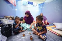 Wilmah bersama dua anaknya antara yang ditempatkan di Pusat Pemindahan Sementara di Program Perumahan Rakyat Bubul Ria setelah rumahnya di Kampung Selamat rosak akibat ribut. Foto Bernama