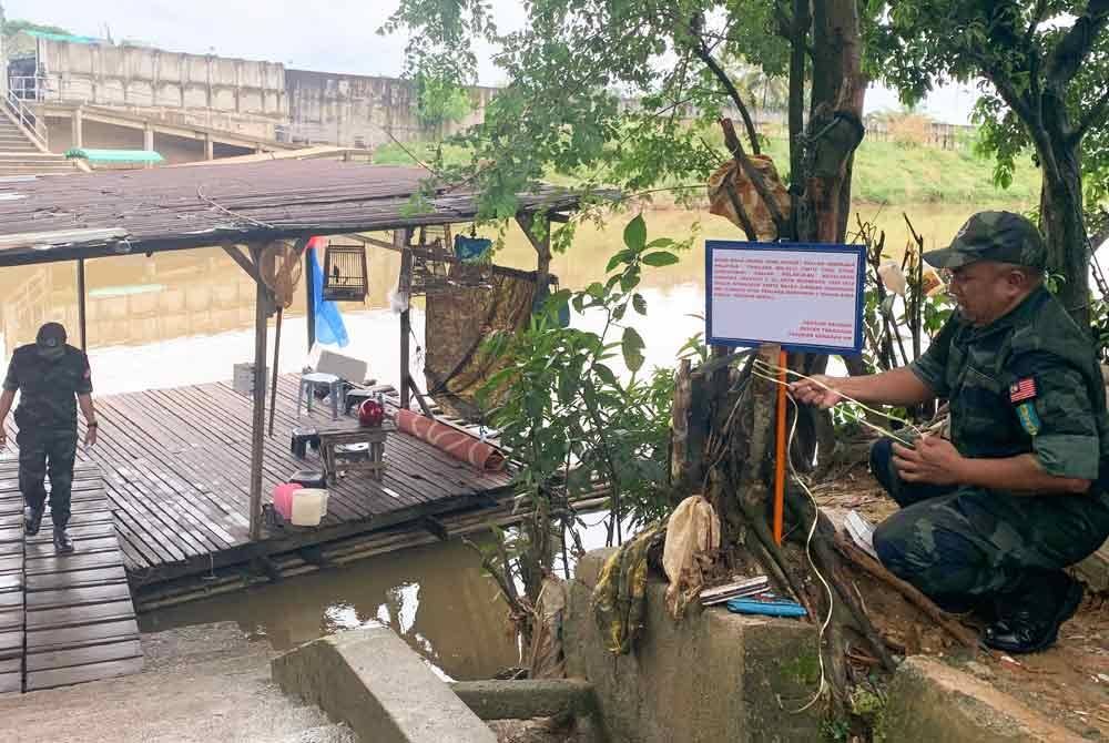 Anggota Pasukan Gerakan Am (PGA) memasang papan tanda peringatan kepada orang ramai supaya jangan menyeberang sempadan melalui Sungai Golok berdekatan pangkalan haram MCA dan Syed Agil, Rantau Panjang pada November lalu. Foto Bernama