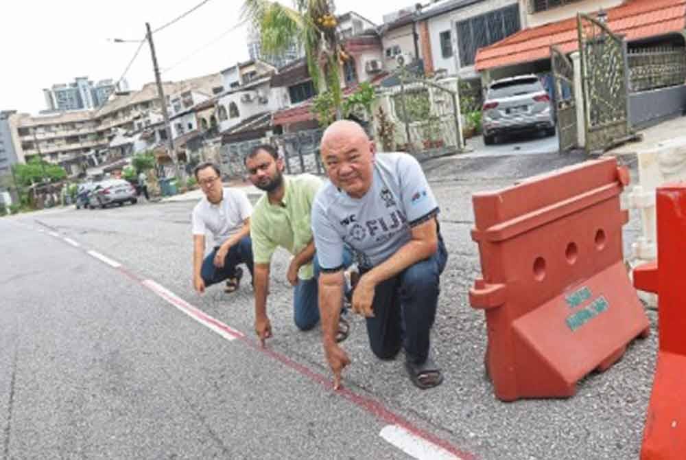 Lim (kanan) bersama dua lagi pemilik rumah teres yang terjejas - Foto The Star