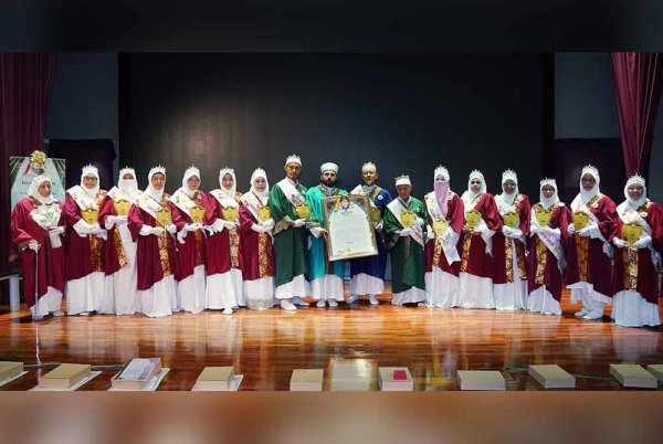 Sheikh Mustapha (tengah) dan Hilmy (lapan dari kanan) bergambar bersama graduan Qiraat pada majlis Konvokesyen Perdana SMSY Qiraat Centre yang diadakan pada Selasa.