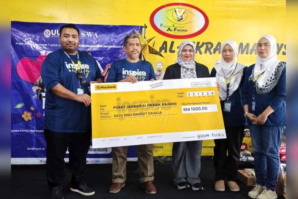 Norman (kiri) menyampaikan sumbangan semasa Program Hari Keluarga di Pusat Jagaan Al-Fikrah Malaysia di Kajang, Ahad lalu.