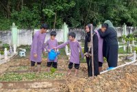 Anak-anak Allahyarham menyiram pusara bapa mereka di Taman Perkuburan Raudhatul Sakinah Sungai Besi.