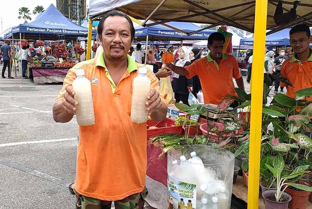 Jamaluddin menunjukkan air nira yang turut dipasarkan di Pasar Tani di daerah ini.