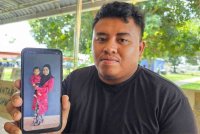 Mohammad Syuqur menunjukkan gambar isteri dan anak bongsu mereka yang meninggal dunia dalam kemalangan dekat Sitiawan pada Khamis.