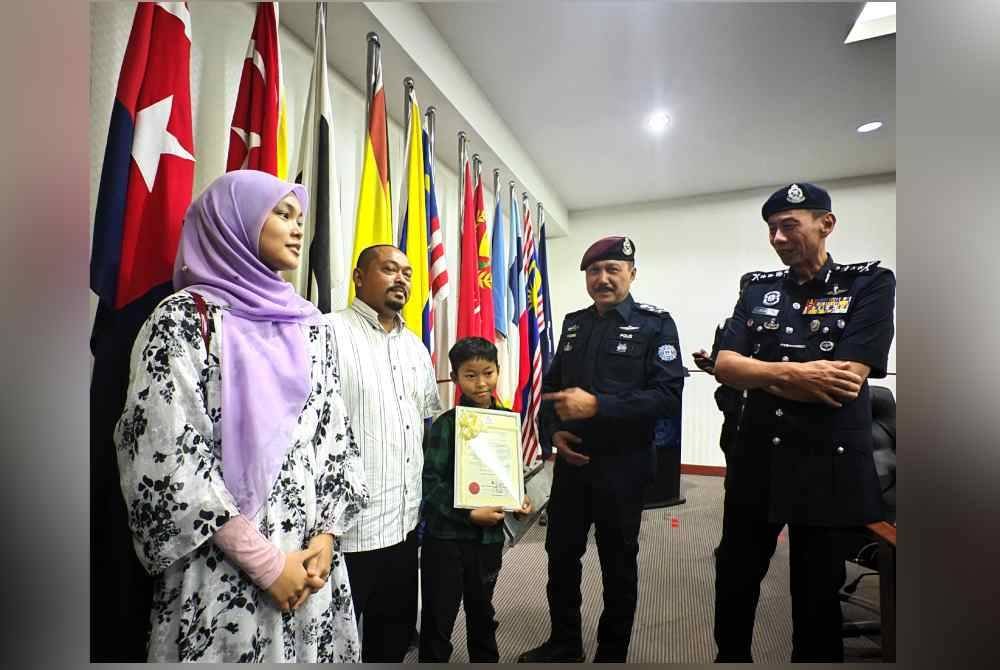 Mohd Yusri (dua dari kanan) beramah mesra dengan Kamrul Ekhsan dan anak-anaknya selepas menerima sijil penghargaan atas tindakan beraninya itu daripada Pengarah JSPT Bukit Aman, Datuk Seri Mohd Yusri Hassan di Ibu Pejabat Polis Daerah Seremban pada Jumaat.