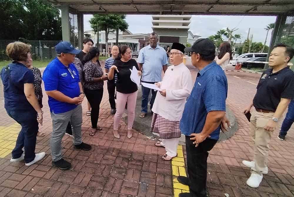 Hassan Karim (dua, kanan), meninjau lokasi berkenaan bersama penduduk pada Jumaat.