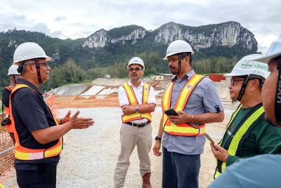 Nik Raisnan (dua dari kanan) mendengar penerangan daripada kakitangan TNB ketika melawat tapak pembinaan empangan hidroelektrik Nenggiri di Kampung Star baru-baru ini. Foto Bernama