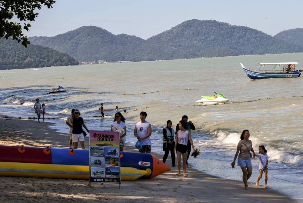 Orang ramai dilihat mengambil kesempatan menikmati cuti dengan berkelah di tepi pantai Batu Ferringhi, Pulau Pinang. Foto Bernama