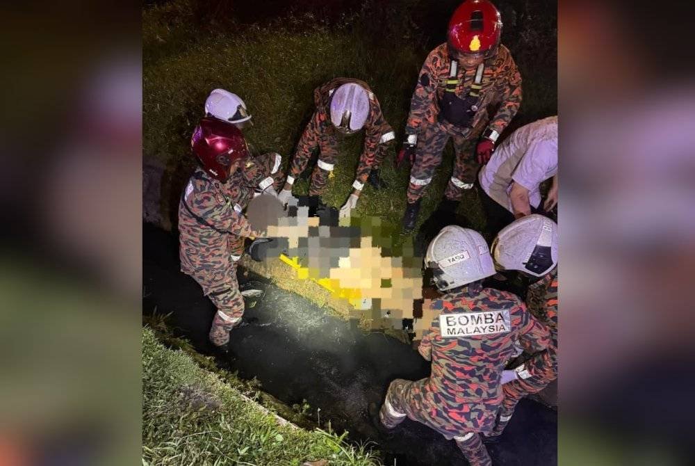 Mangsa cuba dibawa keluar dari longkang oleh anggota bomba. Foto BBP Larkin