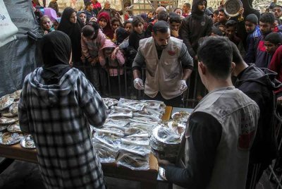 Orang ramai menunggu untuk menerima bantuan makanan di pusat pengedaran makanan di Bandar Gaza. Foto Xinhua