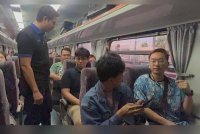 Roshidi (kiri) berbual bersama penumpang yang menaiki kereta api pertama dari Butterworth ke Hatyai.