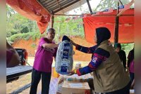 Mohd Daud (kiri) dan Pengerusi MRA Johor, Siti Zubaidah Samat (kanan) ketika menyampaikan bantuan.