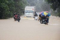 Penduduk dan pengguna jalan raya terpaksa meredah air banjir di jalan utama Kampung Kelewek, Lawang, Batu Gajah. - Foto: Bernama