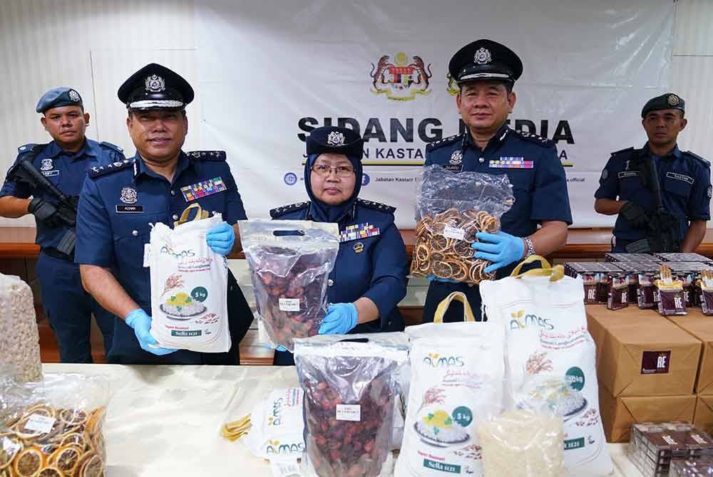 Norlela (tengah) menunjukkan antara kacang serta beras yang dirampas susulan rampasan sebuah kontena di Zon Bebas Pelabuhan Barat di sini, Julai lalu.