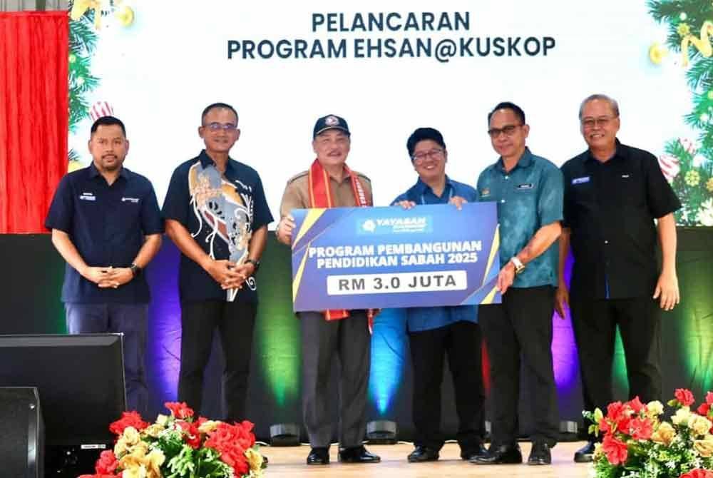 Hajiji (tiga dari kiri), Ewon (tiga dari kanan) dan Philip (kanan) ketika sesi penyerahan replika cek Program Pembangunan Pendidikan Negeri Sabah di Kadamaian Square, Kota Belud.