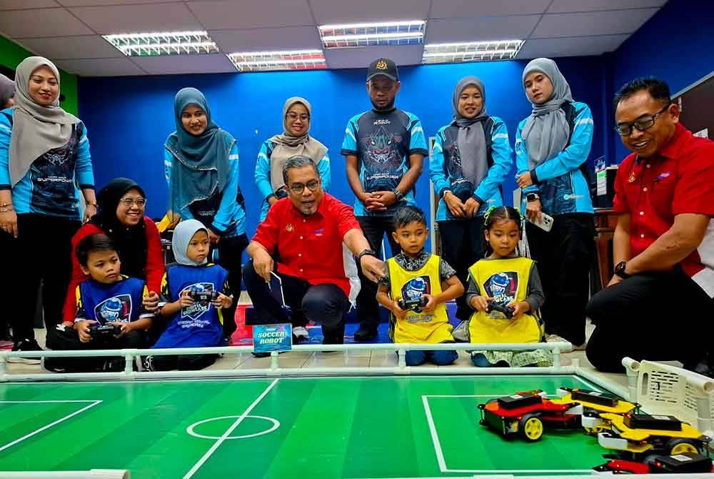 Mohd Hanafiah (tengah) melihat pameran robotik sempena lawatan ke Pusat Kegiatan Masyarakat Kemas Gopeng pada Isnin.