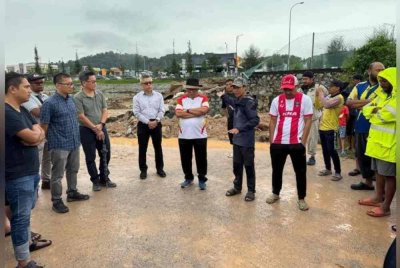 Ab Halim (tengah) sewaktu meninjau lokasi tebing kolam takungan pecah di Taman Seri Alam pada Isnin.