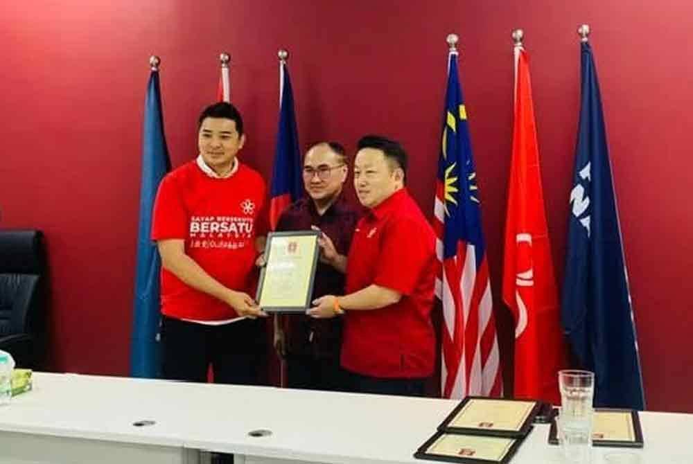 Yew Chin (kanan) memakai baju-T Bersatu di samping Ketua Sayap Hal Ehwal Bukan Melayu Bersatu, Dr Chong Fatt Full dipercayai menyerahkan surat permohonan menyertai parti itu.