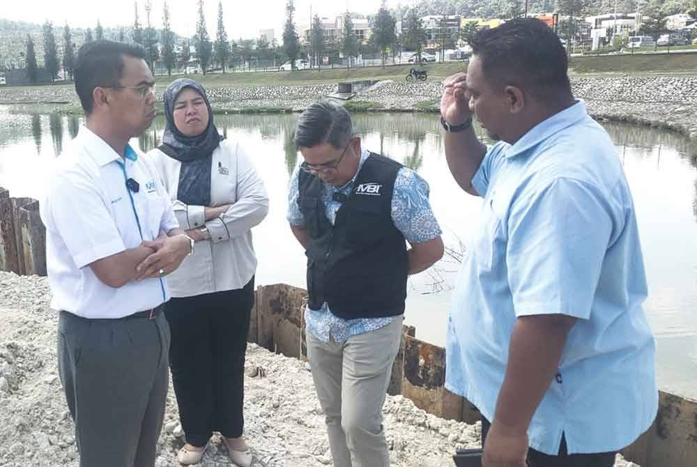 Saipolyazan (kiri) melakukan tinjauan di tapak runtuhan Kolam Takungan Hillpark, Taman Seri Alam, Saujana Utama di sini pada Khamis.