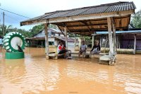 Penduduk melihat keadaan paras air ketika duduk berehat di sebuah wakaf selepas kawasan itu dinaiki air berikutan hujan lebat berterusan semalam ketika tinjauan di Kampung Nibong. Foto Bernama