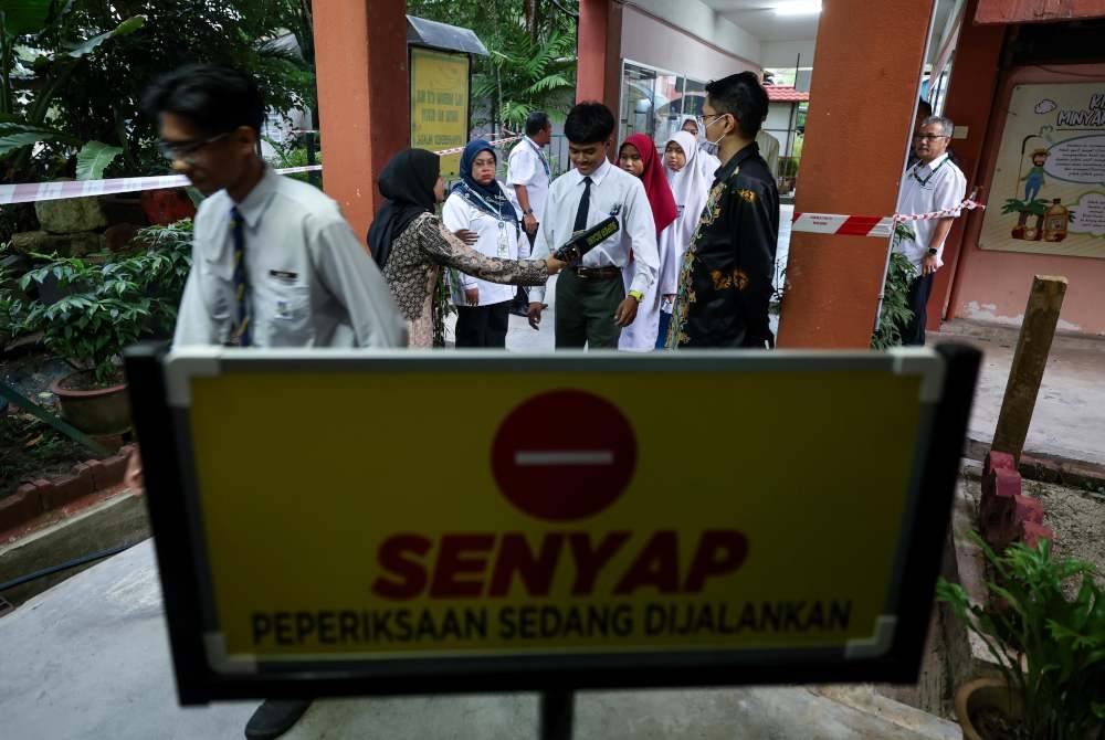 Petugas peperiksaan SPM melakukan imbasan ke atas calon-calon sebelum dibenarkan masuk ke dewan peperiksaan pada hari pertama peperiksaan bertulis SPM 2024 di Sekolah Menengah Kebangsaan Kampong Pasir Puteh pada Khamis. Foto Bernama