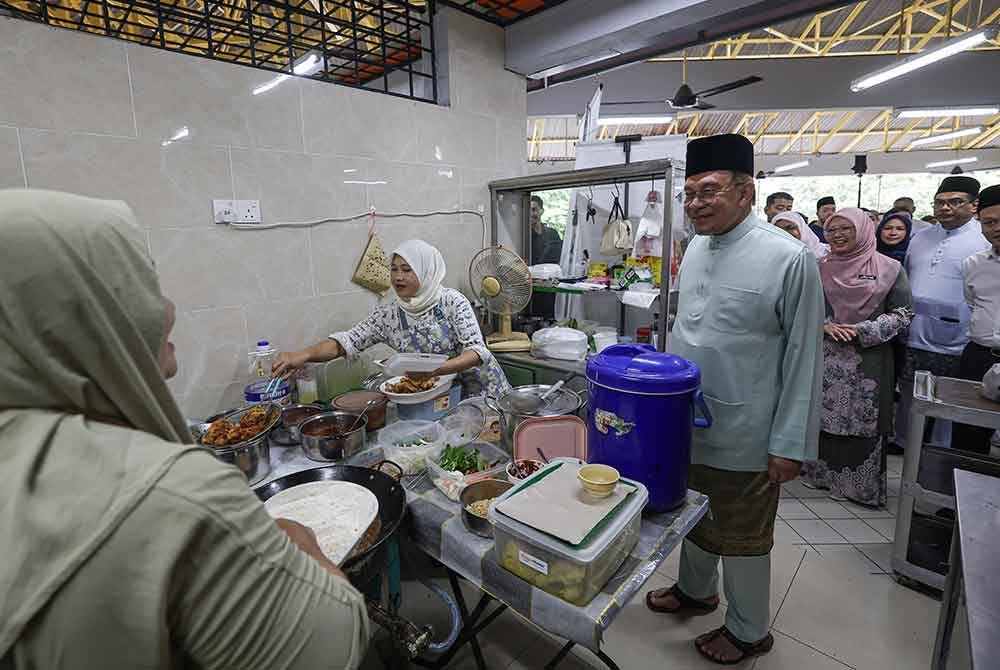 Anwar beramah mesra bersama peniaga ketika meluangkan masa melawat lokasi Lestari Niaga Madani@KL 2 dan menikmati makan tengah hari di Pusat Penjaja Seksyen 10 Wangsa Maju pada Jumaat. Foto Bernama