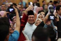 Anwar (tengah) menyantuni sebahagian para penjawat awam pada Majlis Perjumpaan Perdana Menteri Bersama Warga Jabatan Perdana Menteri (JPM) Bagi Bulan Januari dan Amanat Tahun Baharu 2025 di Puspanitapuri pada Jumaat. Foto Bernama