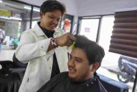 Sallehuddin mengayakan rambut pelanggan di kedainya Takara Barbershop yang terletak di Arked MARA baru-baru ini. Foto Bernama