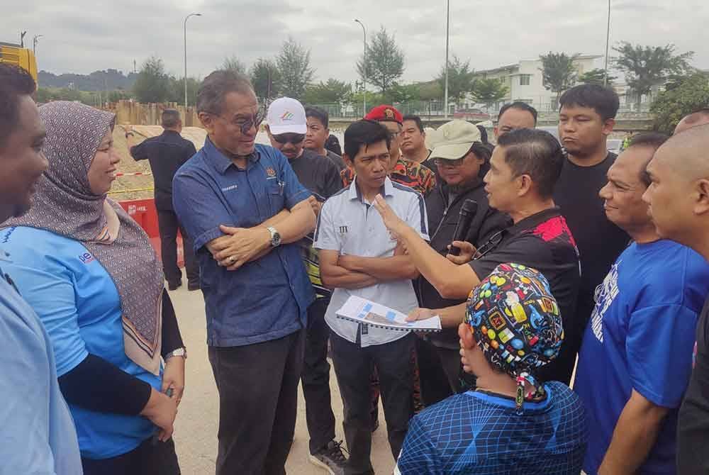 Dr Dzulkefly (tiga dari kiri) meninjau lokasi runtuhan kolam takungan di Taman Seri Alam, Saujana Utama pada Sabtu.