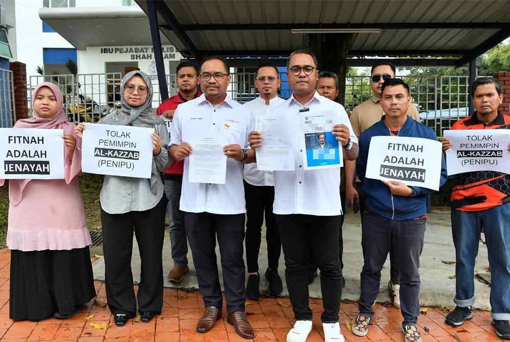 Azli (tiga kiri) bersama Abbas Salimi (tiga kanan) selepas membuat laporan polis di Balai Polis Seksyen 9 Shah Alam pada Sabtu. Foto Bernama