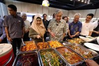 Ahmad Zahid (tiga dari kanan) bersama isteri Datin Seri Hamidah Khamis melihat juadah pada majlis pembukaan Kuali Cafe@UKM di Bangunan Pusanika Universiti Kebangsaan Malaysia (UKM), di sini hari ini. Foto Bernama