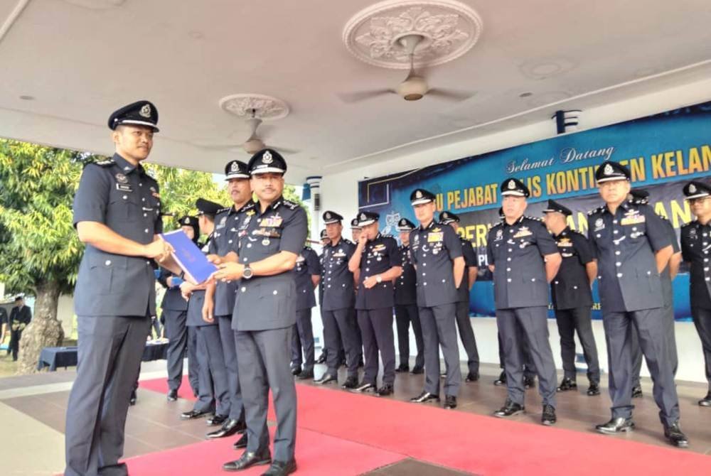 Mohd Yusoff (kanan) menyampaikan sijil kenaikan pangkat kepada pegawai polis Majlis Perhimpunan Bulanan Warga Ibu Pejabat Polis Kontinjen Kelantan pada Ahad.