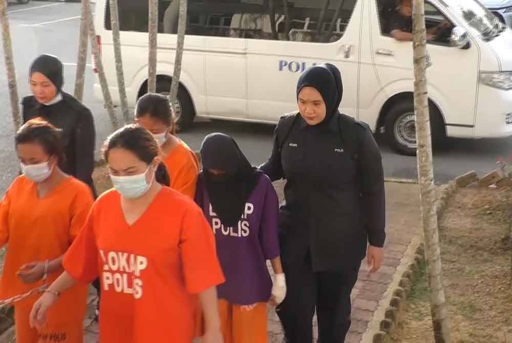 Remaja perempuan 14 tahun (dua dari kanan) diiringi polis ketika dibawa ke Mahkamah Bukit Mertajam, pada Isnin.