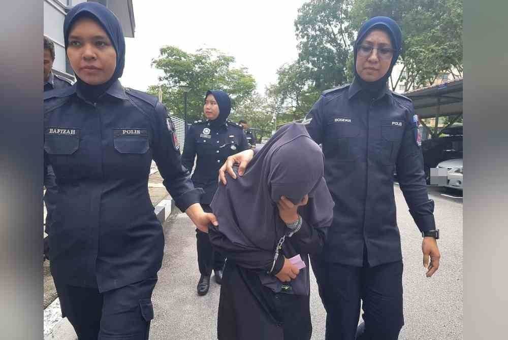 Puteri Nurin Amalina (tengah) diiring polis ketika hadir ke mahkamah pada September tahun lalu. Gambar fail 