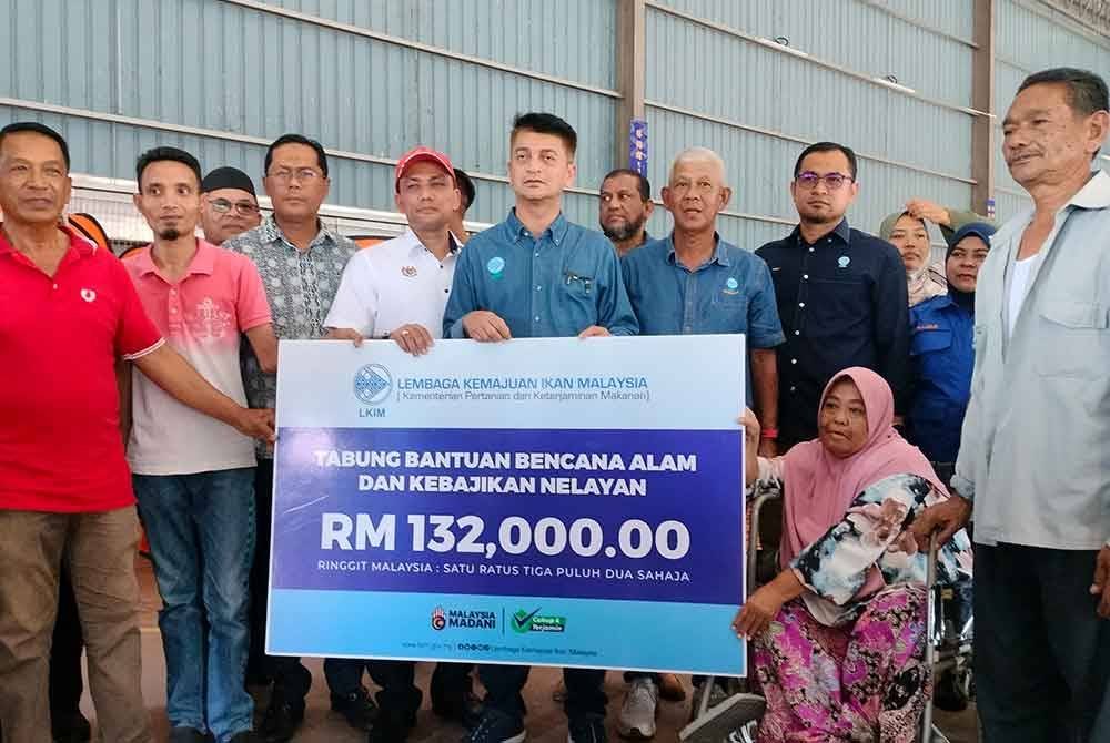 Muhammad Faiz menyampaikan sumbangan kepada mangsa kebakaran di Tanjung Dawai Kedah.