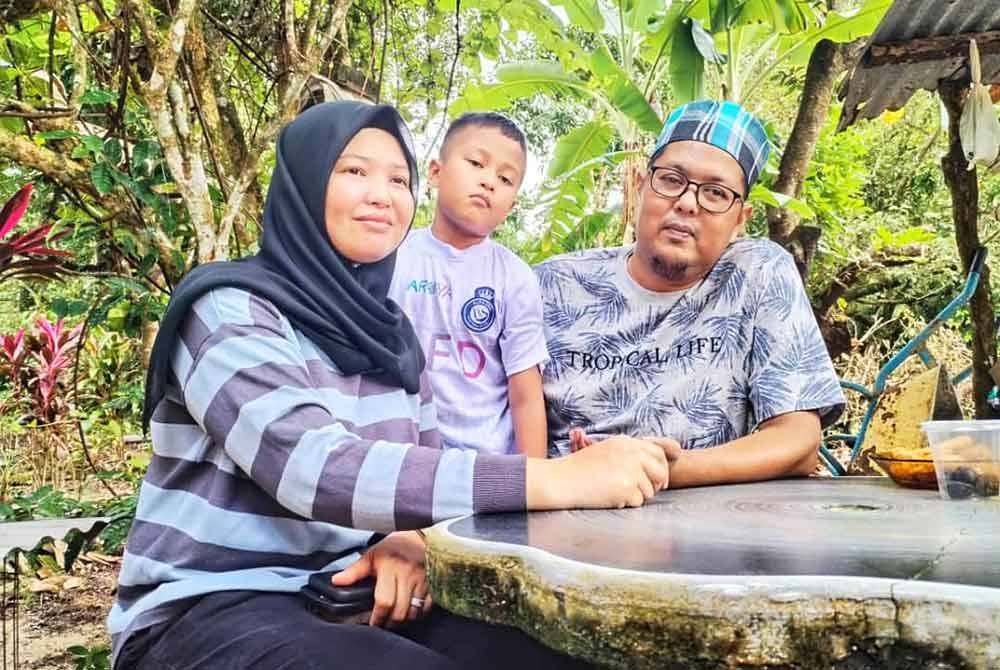 Nik Mohd Azwa di samping isteri dan anaknya, Nik Umar Qalish yang berusia sembilan tahun ketika ditemui pemberita di Kampung Padang Luas, Besut.