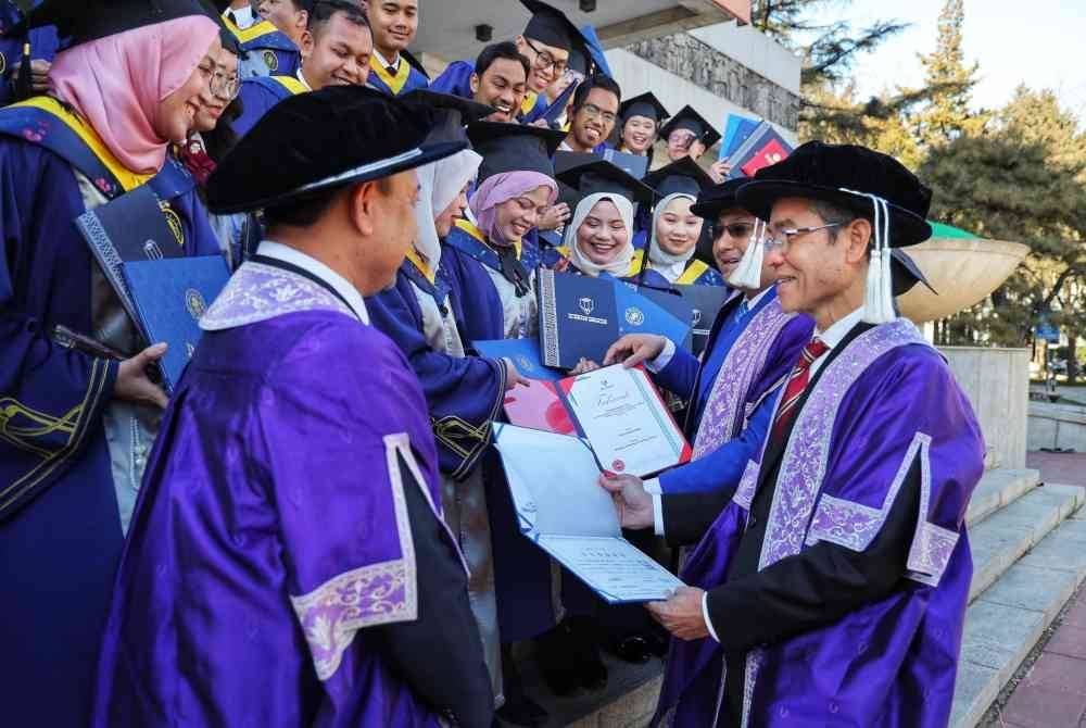 Anesee Ibrahim (kanan) dan Ahmad Ziad bersama pelajar UMPSA dalam majlis graduasi yang berlangsung di BJTU, Beijing,China. Foto ihsan UMPSA