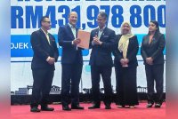 Mohamad Azhan (tiga dari kanan) menyerahkan Surat Permakluman projek RMK12 RP5 tahun 2025 kepada Mohd Zahari.