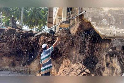 Ghazali menunjukkan kesan hakisan yang berlaku di kedai makannya di Kampung Tanjung, dekat Batu Rakit, Kuala Nerus.