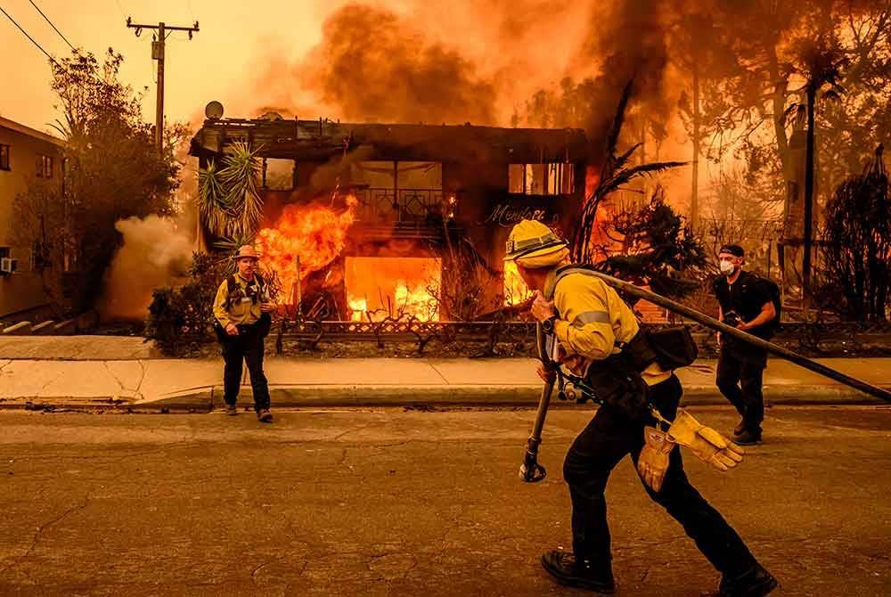 Anggota bomba berusaha memadamkan bangunan aparment semasa kebakaran melanda Altadena di Los Angeles, California. - AFP